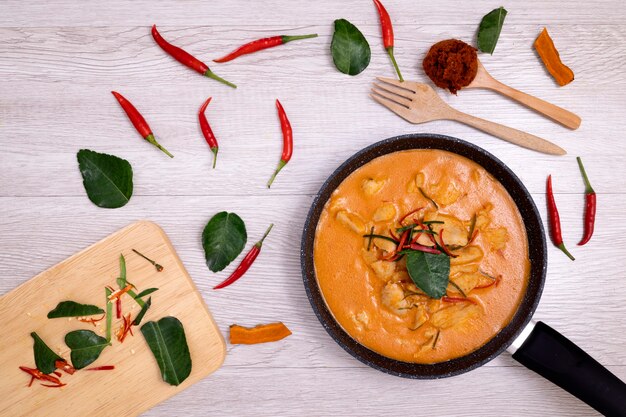 Curry de poulet pandan thaï avec feuilles de citron vert kaffir et décoration de piment rouge.