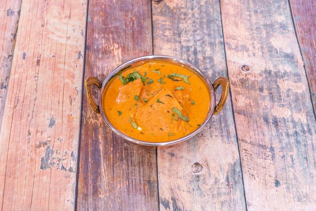 Curry de poulet tikka masala au persil monté dans un bol traditionnel du restaurant pakistanais populaire