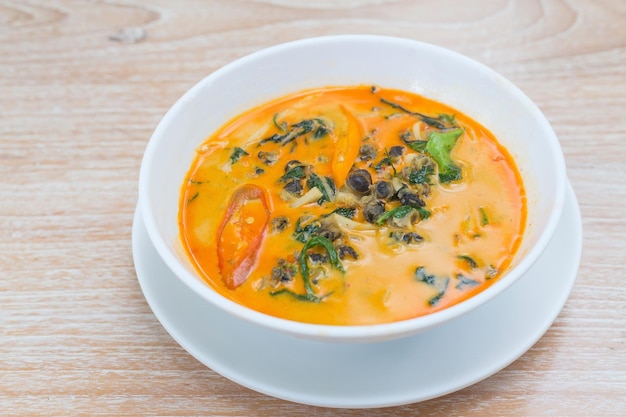 Curry thaï épicé avec escargot de rivière et feuille de bétel dans du lait de coco frais servi dans un bol blanc