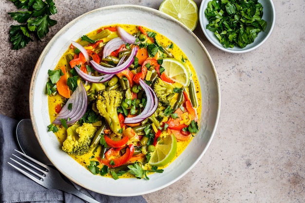 Curry vert thaï vegan avec brocoli, poivre, haricots verts et lait de coco dans un bol, vue du dessus.