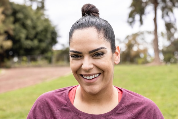 Photo curvy woman smiling en plein air au parc de la ville - se concentrer sur le visage