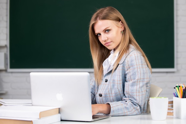 Cute teen girl school student écrire des notes regarder la vidéo webinaire en ligne apprendre sur ordinateur portable Webinaire elearning à l'école l'enseignement à distance