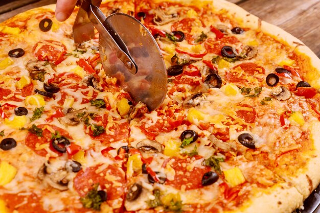 Cutter coupe ronde pizza suprême, gros plan.