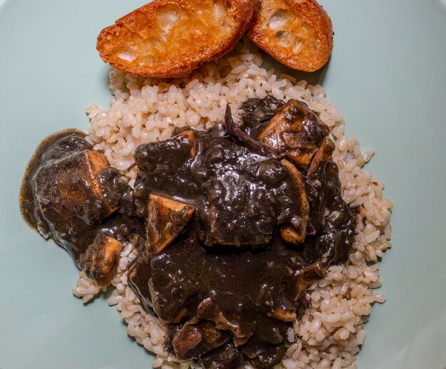 Cuttlefish dans son encre avec du riz brun et des croutons Galice Espagne