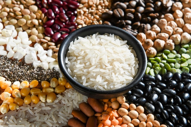 Cuvette avec les riz blancs crus sur le divers grain de graines