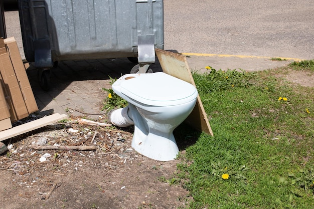 Une cuvette de toilette en céramique blanche jetée à la décharge