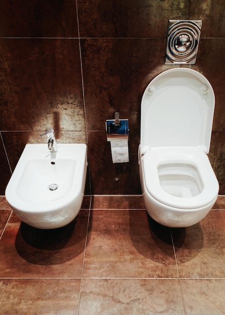 Cuvette de toilette en céramique ouverte et bidet dans la salle de bain