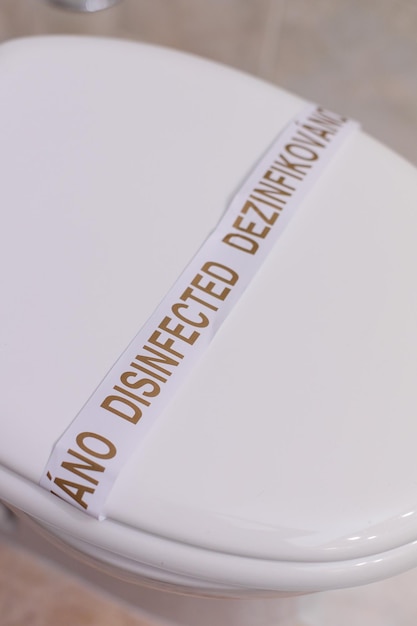 Cuvette de toilette désinfectée dans une cuvette de toilette lavée d'hôtel avec un autocollant dans un gros plan d'hôtel