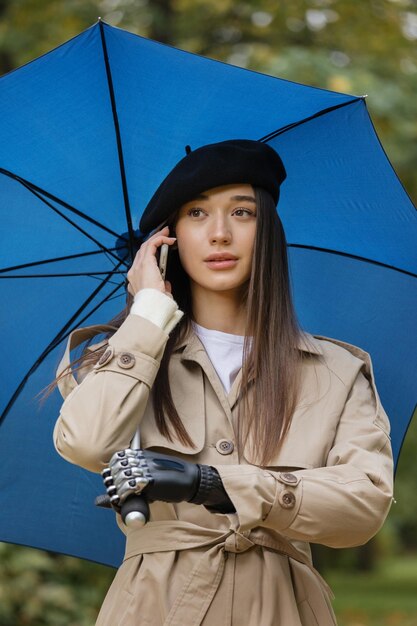 Photo une cyberfemme sous un parapluie avec une prothèse bionique sur son bras parle au téléphone et