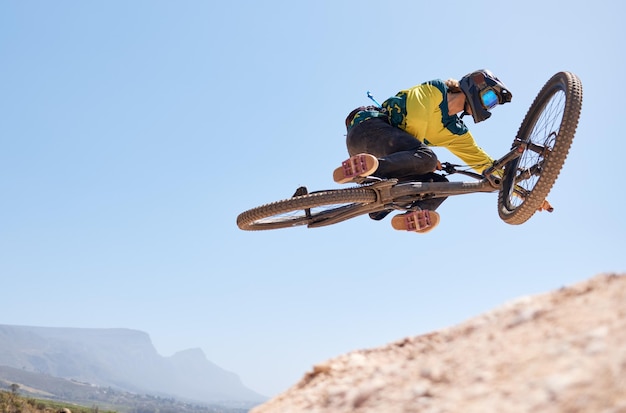 Cyclisme dans la nature et saut d'homme avec vélo dans les performances de cascades aériennes et exercice de sport en plein air au Canada Aventure en vélo de montagne et forme physique d'une personne avec une action de vol à vélo avec une maquette du ciel