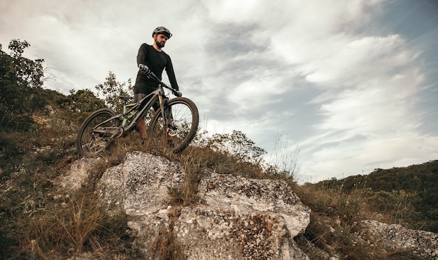 Cycliste barbu avec vélo en descendant la colline