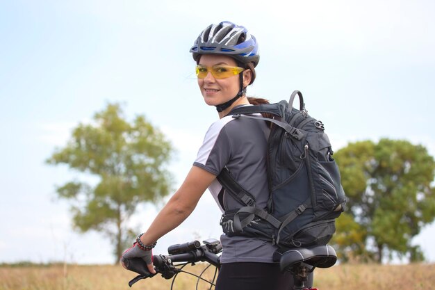 Cycliste belle femme roule sur le terrain à vélo. Mode de vie sain et sport.