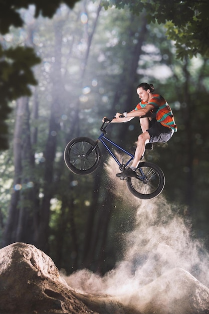 Cycliste Bmx trompant sur les collines de la forêt