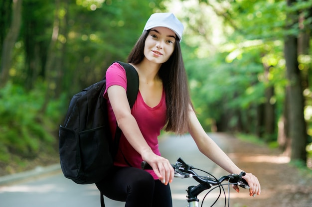 Cycliste avec capuchon blanc sur un vélo, le sport des femmes dans la forêt