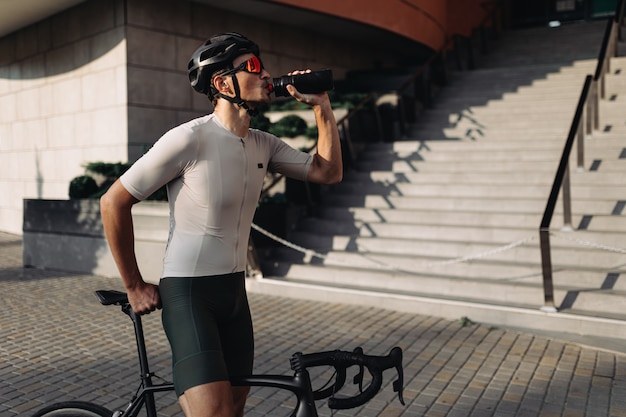 Cycliste et casque et verres d'eau potable à l'extérieur