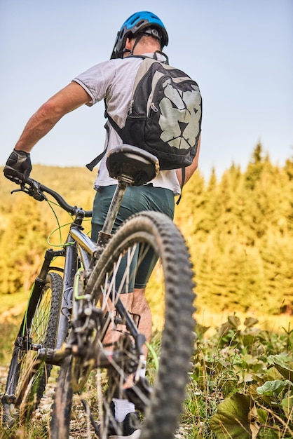 Un cycliste fait du vélo à côté de lui à travers les routes forestières. Photo de haute qualité