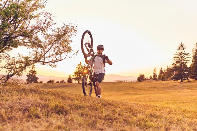 Un cycliste fait du vélo sur des routes forestières au coucher du soleil