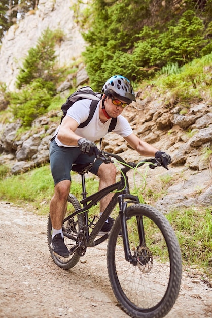 Un cycliste fait du vélo sur des routes forestières extrêmes et dangereuses Mise au point sélective