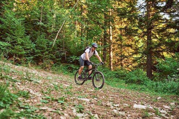 Un cycliste fait du vélo sur des routes forestières extrêmes et dangereuses Mise au point sélective