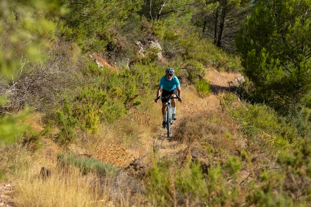 Un cycliste masculin dans une forêt méditerranéenne de gravier à vélo à Alicante Espagne