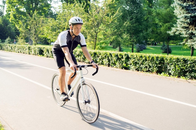 Un cycliste masculin fait du vélo de route en train dans une combinaison de vélo Enregistrement sportif dans la ville pendant un certain temps