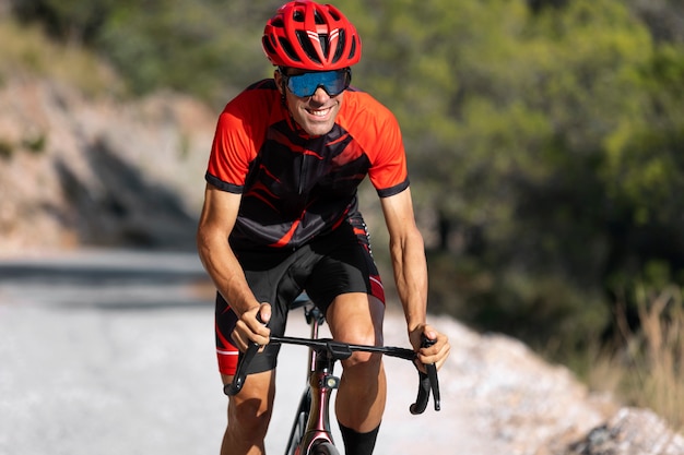 Cycliste masculin avec formation de casque sur le vélo à l'extérieur