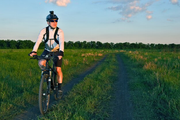 Le cycliste monte sur la route dans le domaine