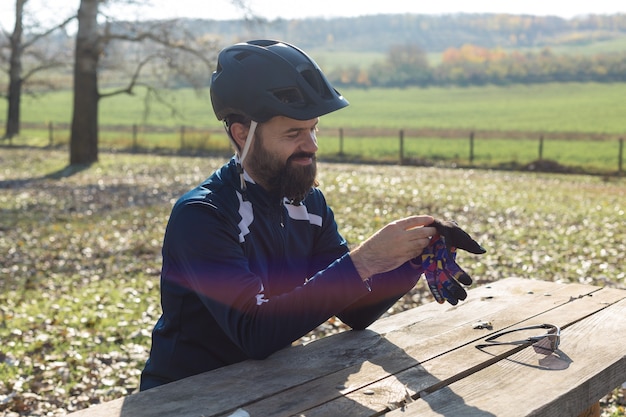 Un cycliste en pantalon et veste polaire sur un vélo semi-rigide en carbone moderne se promène en tout-terrain