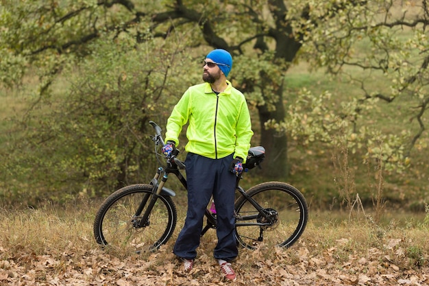 Cycliste en pantalon et veste polaire sur un vélo semi-rigide moderne en carbone avec fourche à suspension pneumatique