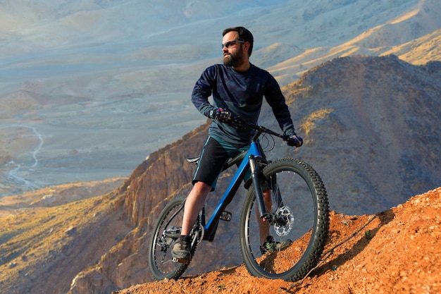 Cycliste en pantalon et veste polaire sur un vélo semi-rigide moderne en carbone avec fourche à suspension pneumatique