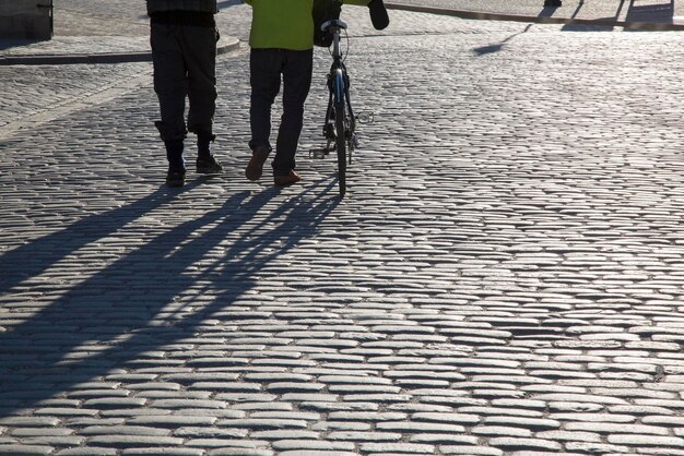 Cycliste et piéton sur la rue pavée à Stockholm, Suède