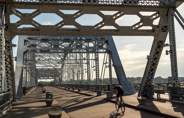 Photo cycliste sur pont piétonnier john seigenthaler ou shelby street crossing au lever du soleil à nashville