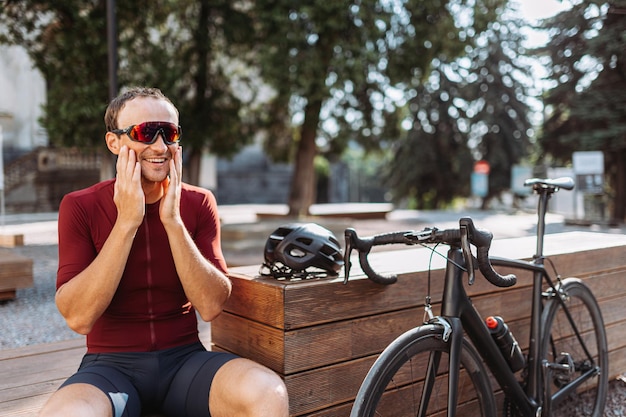 Cycliste positif reposant sur un banc en bois à l'extérieur