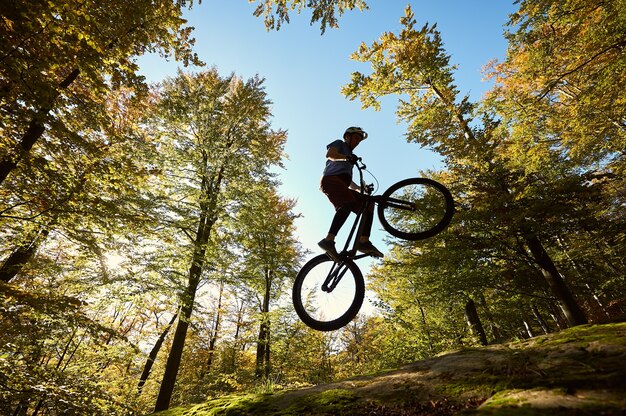 Cycliste professionnel en équilibre sur vélo d'essai au coucher du soleil