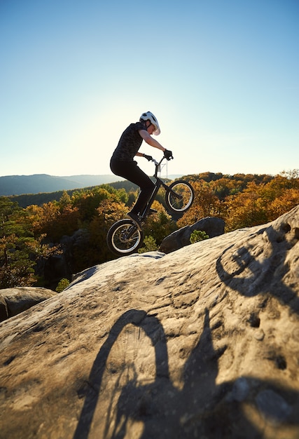 Cycliste professionnel en équilibre sur vélo d'essai au coucher du soleil