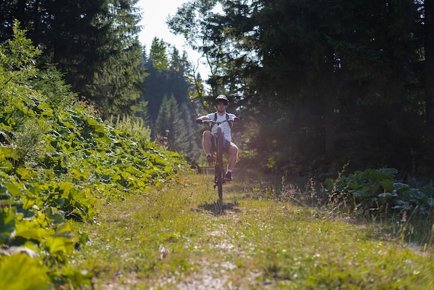 Cycliste professionnel de vélo de montagne parcourant un sentier dans la forêt Sport d'aventure extrême en plein air