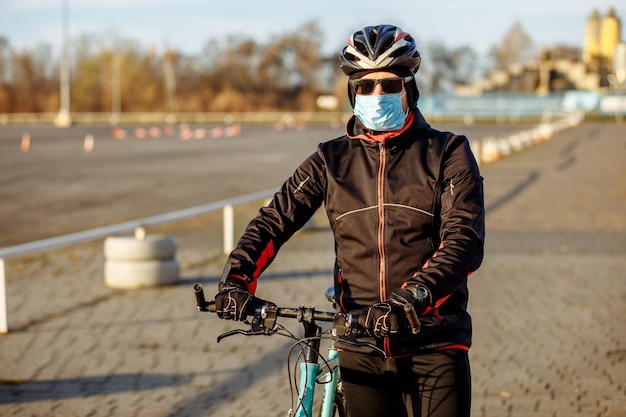 Un cycliste en quarantaine fait du vélo dans un masque