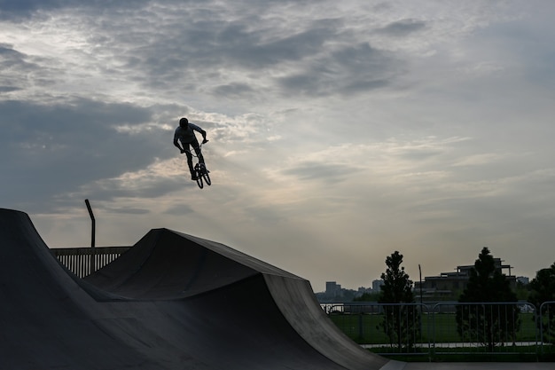 Le cycliste roule dans un parc extrême. Le cascadeur. Le skate park, rollerdrome, rampes quarter et half pipe. Sport extrême, culture urbaine des jeunes pour l'activité de rue des adolescents.