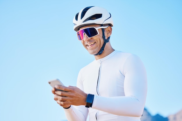 Un cycliste se détend ou un homme heureux avec un téléphone sur les réseaux sociaux pour un exercice d'entraînement sportif ou un entraînement de fitness Pause sourire ou un motard se reposant avec une application mobile pour la navigation en réseau ou la recherche d'informations