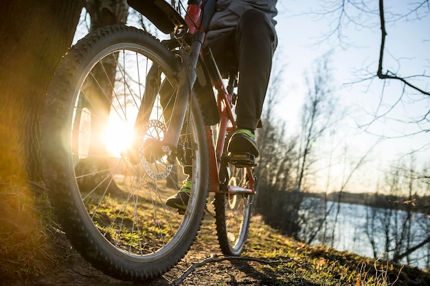 Cycliste se reposant après une balade le long des berges de la rivière le soir au soleil couchant