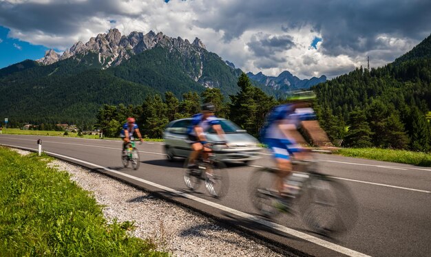 Les cyclistes de la bicyclette sur la route en arrière-plan les Dolomites Alpes Italie. Attention - prise de vue authentique, il y a un flou de mouvement.