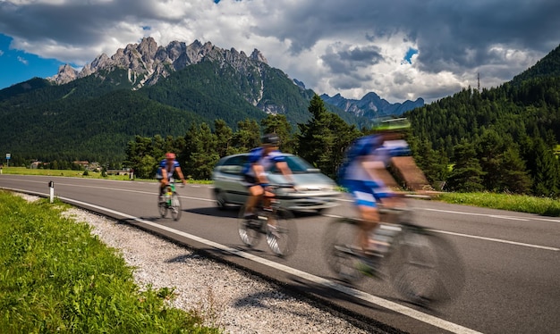 Les cyclistes à vélo sur la route en arrière-plan les Alpes Dolomites Italie Attention prise de vue authentique il y a un flou de mouvement