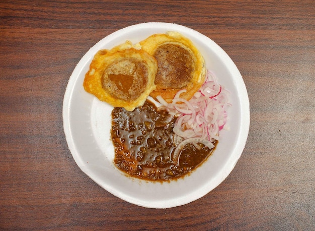 Daal kabab avec chutney de sauce tomate épicée en vue de dessus de plaque blanche sur une table en bois sombre