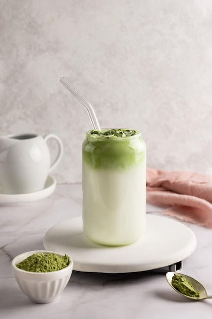 Dalgona matcha latte en verre, thé vert fouetté au lait.