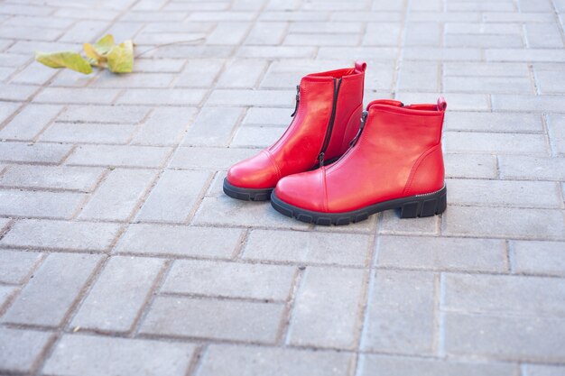 Sur les dalles en automne se trouve une paire de chaussures rouges pour femmes.