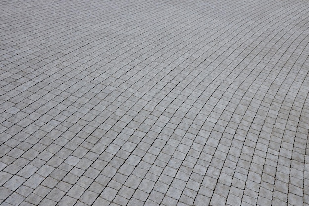 Dalles de couleur grise dans le trottoir de la rue piétonne Motif pavé rugueux avec de nombreuses pierres de forme carrée