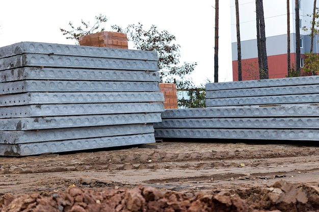 Les dalles de sol en béton armé sont stockées sur le chantier de construction Gros plan Structures et matériaux de construction en béton armé