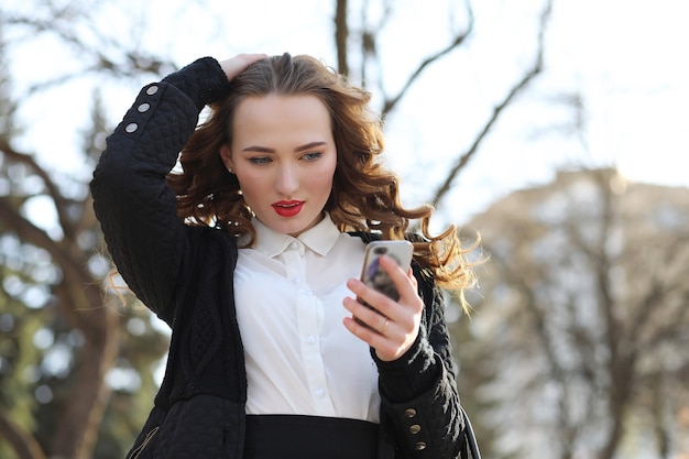 Dame d'affaires en costume à l'extérieur avec un téléphone portable