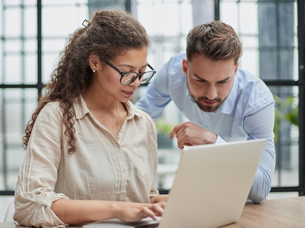 Dame d'affaires regardant un ordinateur portable avec son collègue au bureau