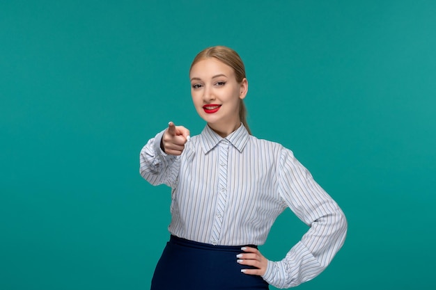 Dame d'affaires souriant jolie fille en tenue de bureau pointant à l'écran